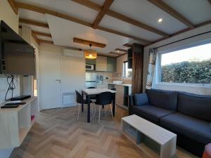 ein Wohnzimmer mit einem Sofa und einem Tisch in der Unterkunft Camping Le Transat in Foulerot