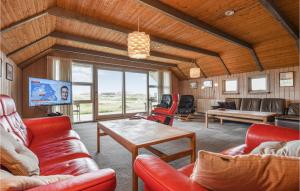 uma sala de estar com cadeiras vermelhas e uma mesa em Beautiful Home In Ringkbing With Kitchen em Søndervig