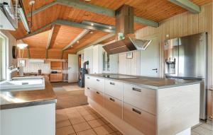 uma grande cozinha com tectos de madeira e balcões de madeira em Beautiful Home In Ringkbing With Kitchen em Søndervig