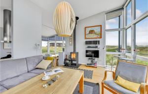 sala de estar con sofá y mesa en Amazing Home In Ringkbing With House A Panoramic View, en Søndervig