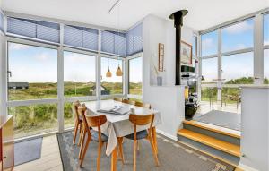 a dining room with a table and chairs and large windows at Holiday Home Holdvej in Ringkøbing +27 photos