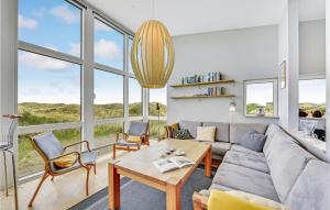 a living room with a couch and a table and chairs at Holiday Home Holdvej in Ringkøbing