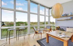 a living room with large windows and a table and chairs at Holiday Home Holdvej in Ringkøbing