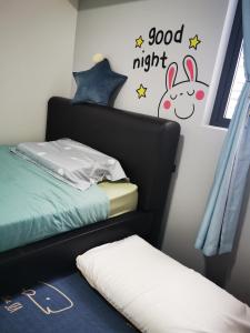 a bedroom with a bed and a goodnight sign on the wall at Aishiteru Homestay in Kuala Lumpur