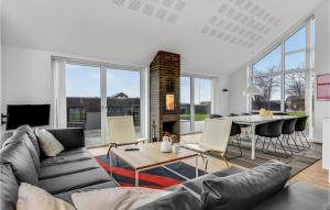 3 Bedroom Cozy Home In Haderslev في Kelstrup Strand: غرفة معيشة مع أريكة وطاولة