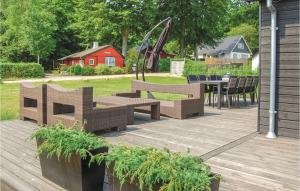 una terrazza in legno con sedie, tavolo e parco giochi di 3 Bedroom Cozy Home In Haderslev a Kelstrup Strand