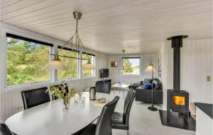 a living room with a table and a fireplace at Holiday Home Fyrmarken Hvide Sande in Nørre Lyngvig