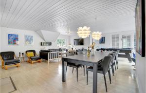 UlfborgにあるAwesome Home In Ulfborg With Outdoor Swimming Poolのダイニングルーム、リビングルーム(テーブル、椅子付)