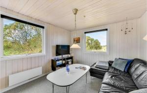 a living room with a couch and a table at Holiday Home Fyrmarken Hvide Sande in Nørre Lyngvig