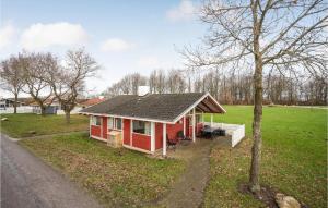 a red house in a field with a tree at Golfparken in Løjt