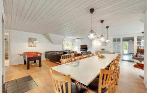 a dining room and kitchen with a large table and chairs at Gorgeous Home In Ulfborg With Private Swimming Pool, Can Be Inside Or Outside in Øby