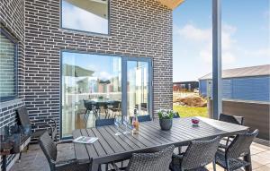 patio con mesa de madera y sillas en el balcón en Lovely Home In Ringkbing With House A Panoramic View, en Søndervig