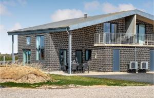 uma casa de tijolos com duas cadeiras e uma varanda em Awesome Home In Ringkbing With 3 Bedrooms And Wifi em Søndervig