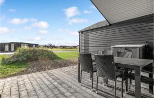 eine Terrasse mit einem Tisch und Stühlen auf einem Haus in der Unterkunft Awesome Home In Ringkbing With Kitchen in Søndervig