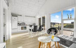 eine offene Küche und ein Wohnzimmer mit einem Tisch und Stühlen in der Unterkunft Awesome Home In Ringkbing With Kitchen in Søndervig