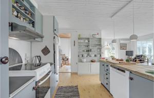 a kitchen with white cabinets and white counters at Holiday Home Svenstibakkevej Denm in Lild Strand