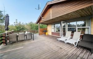 a wooden deck with chairs and tables on it at 2 Bedroom Beautiful Home In Roslev in Flovtrup