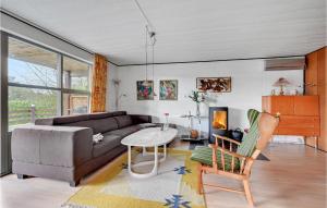 a living room with a couch and a table at 2 Bedroom Beautiful Home In Roslev in Flovtrup