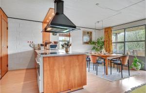 a kitchen with a table and a stove top oven at 2 Bedroom Beautiful Home In Roslev in Flovtrup