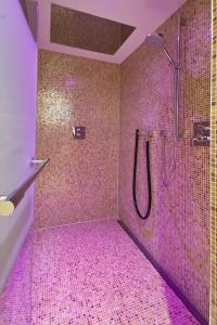 y baño con ducha de azulejos rosados. en Ostsee Lodges mit Wellnessbereich, en Timmendorfer Strand 107 fotos más