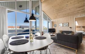 Lild StrandにあるAmazing Home In Frstrup With 4 Bedrooms, Sauna And Wifiのリビングルーム(テーブル、椅子、ソファ付)