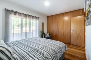 um quarto com uma cama e uma janela em Bay View-T1 em São Martinho do Porto