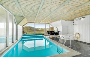 an indoor pool with blue water in a house at Awesome Home In Ringkbing With 4 Bedrooms, Sauna And Indoor Swimming Pool in Søndervig