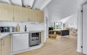 a kitchen with white appliances and a living room at Beautiful Home In Ringkbing With 3 Bedrooms, Sauna And Wifi in Søndervig