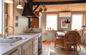 cocina con fregadero y mesa con sillas en 2 Bedroom Amazing Home In Lemvig, en Nørby
