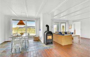 a living room with a fireplace and a table and chairs at Four-Bedroom Holiday Home In Ringkobing in Ringkøbing +26 photos
