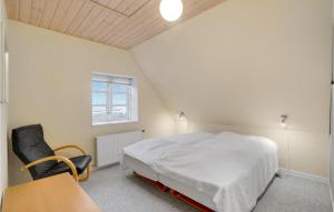 a bedroom with a bed and a chair and a window at Nice Home In Thyborøn With Wifi in Thyborøn