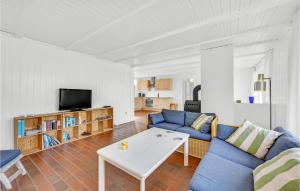 a living room with a blue couch and a tv at Four-Bedroom Holiday Home In Ringkobing in Ringkøbing