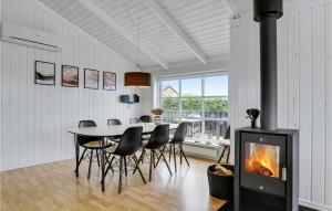 uma sala de jantar com lareira, mesa e cadeiras em 5 Bedroom Amazing Home In Haderslev em Flovt