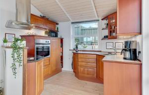 a kitchen with wooden cabinets and a large window at Søglimt in Hejls