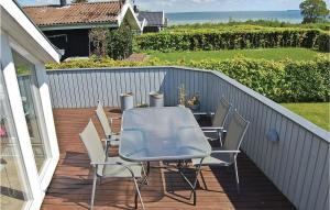 eine Terrasse mit einem Tisch und Stühlen auf einer Terrasse in der Unterkunft Stunning Home In Bjert With Kitchen in Sønder Bjert