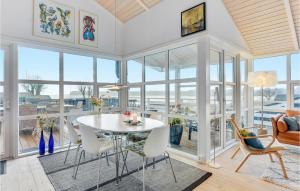 a dining room with a table and chairs and windows at Søglimt in Hejls