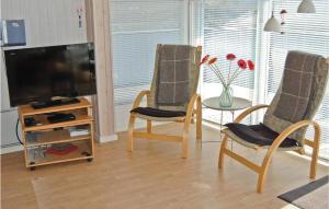 ein Wohnzimmer mit 2 Stühlen und einem TV in der Unterkunft Stunning Home In Bjert With Kitchen in Sønder Bjert