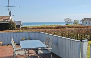 einen Tisch und Stühle auf einer Terrasse mit Meerblick in der Unterkunft Stunning Home In Bjert With Kitchen in Sønder Bjert