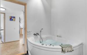 a white tub in a bathroom with a shower at Amazing Home In Hvide Sande With Wifi in Hvide Sande +23 photos