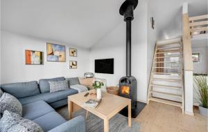 een woonkamer met een blauwe bank en een houtkachel bij Amazing Home In Hvide Sande With Wifi in Hvide Sande