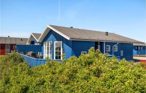 een blauw huis met een zwart dak bij Amazing Home In Hvide Sande With Wifi in Hvide Sande