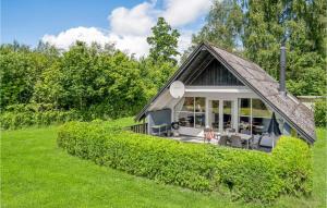 ein Haus mit einem Strohdach auf einem grünen Feld in der Unterkunft Beautiful Home In Herning With Kitchen in Kølkær