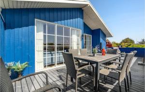 een tafel en stoelen op een terras met een blauw gebouw bij Amazing Home In Hvide Sande With Wifi in Hvide Sande