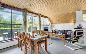 uma sala de estar com uma mesa e cadeiras e um sofá em Beautiful Home In Herning With Kitchen em Kølkær