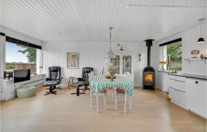 a dining room with a table and chairs and a fireplace at Nice Home In Haderslev With Kitchen in Kelstrup Strand