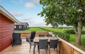 a wooden deck with a table and chairs on it at Nice Home In Haderslev With Kitchen in Kelstrup Strand
