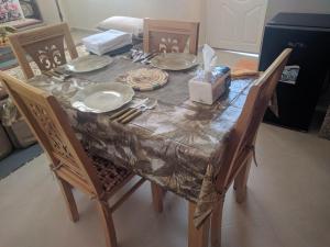 a dining room table with a tablecloth and plates and chairs at amal's apart&studio in Agadir