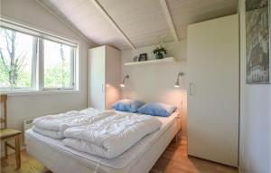 a bedroom with a large white bed with blue pillows at Nice Home In Give With 3 Bedrooms, Sauna And Wifi in Lindet