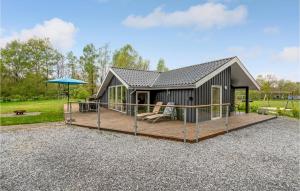 een hut met een terras en een parasol bij Gorgeous Home In Give With Wifi in Lindet