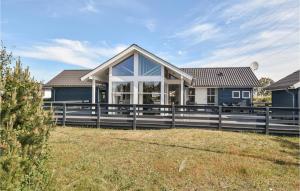 a house with a fence in front of it at Stunning Home In Hvide Sande With House A Panoramic View in Hvide Sande